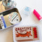 tin with matchbook print with tiger with CREATIVE SPARK! across the front with matchbook sticker flakes