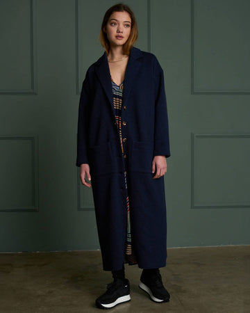 model wearing navy midi length coat with patch front pockets