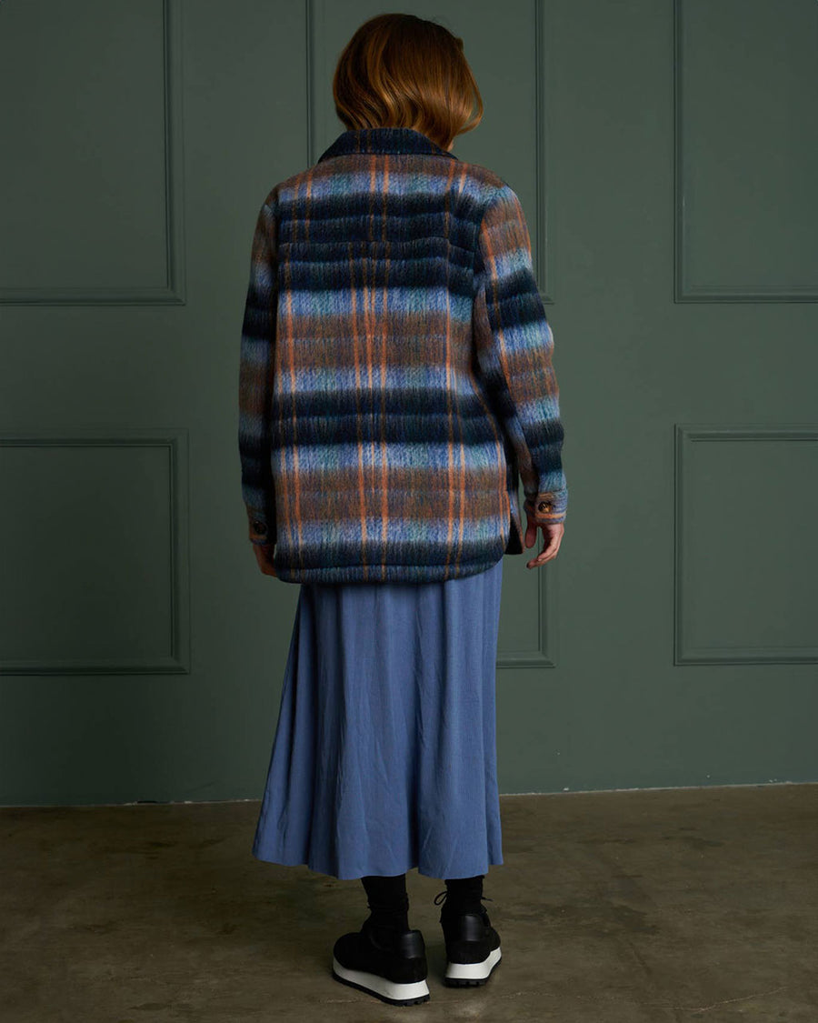 backview of model wearing blue and brown wool plaid jacket