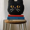 black cat beaded throw pillow on a stack of books