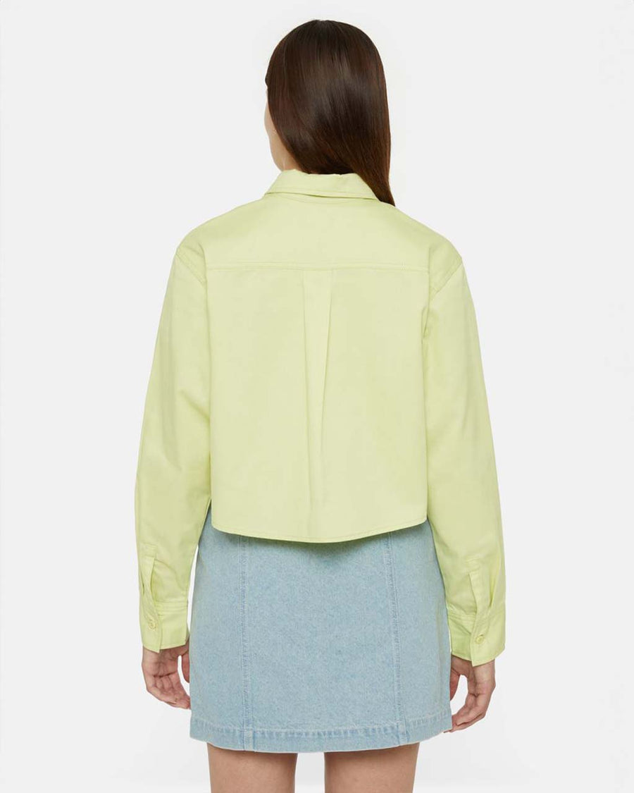 back view of model wearing cropped pale green button up top woth collar and extended front patch pockets