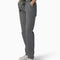 side view of model wearing black and white thin pinstripe carpenter pants with black dickies belt