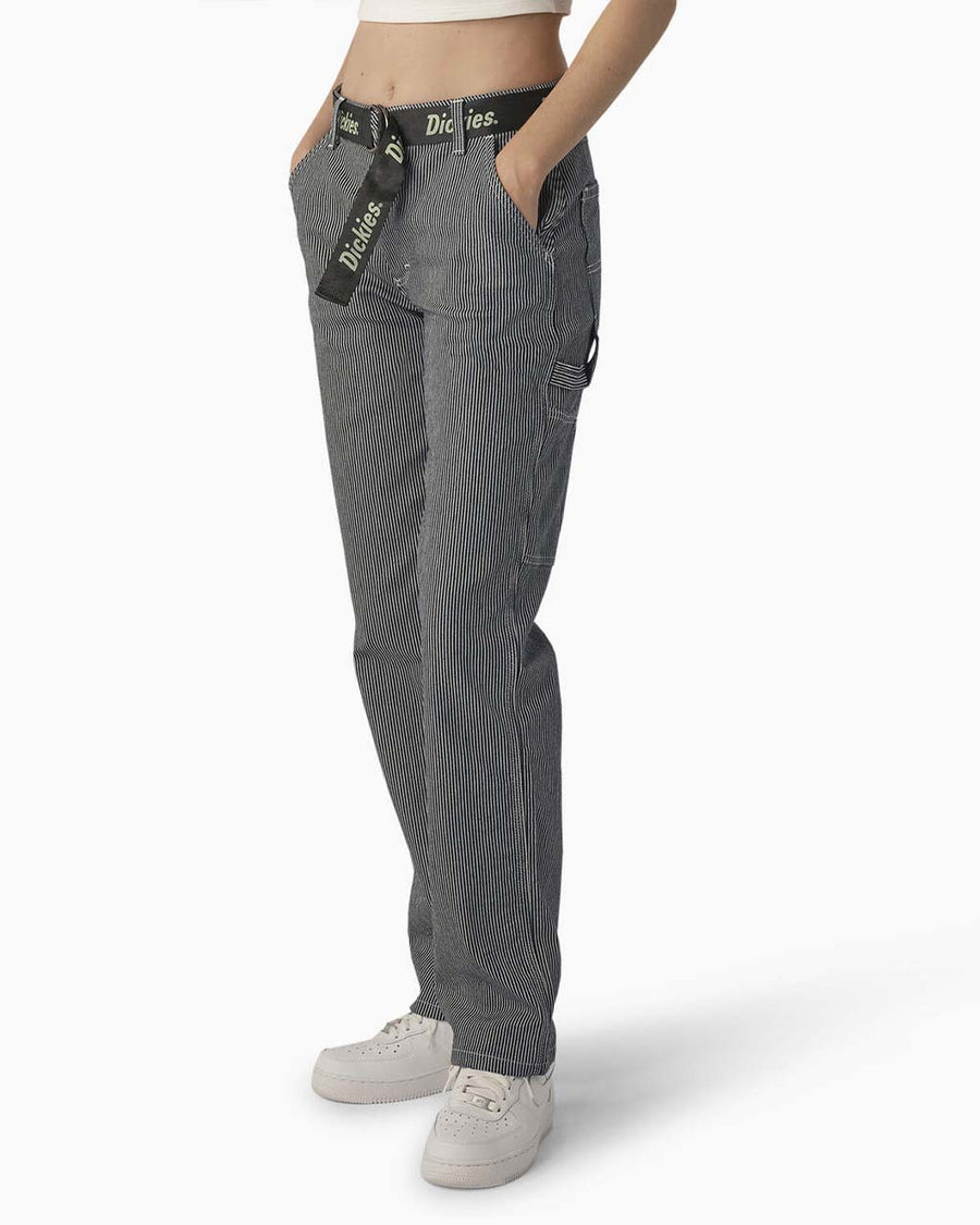 side view of model wearing black and white thin pinstripe carpenter pants with black dickies belt