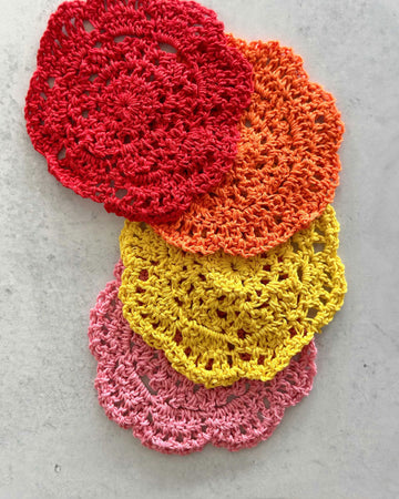 red, orange, yellow and pink crochet coasters