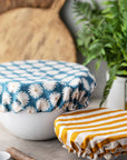 gold and white stripe and large blue daisy bowl covers on bowls