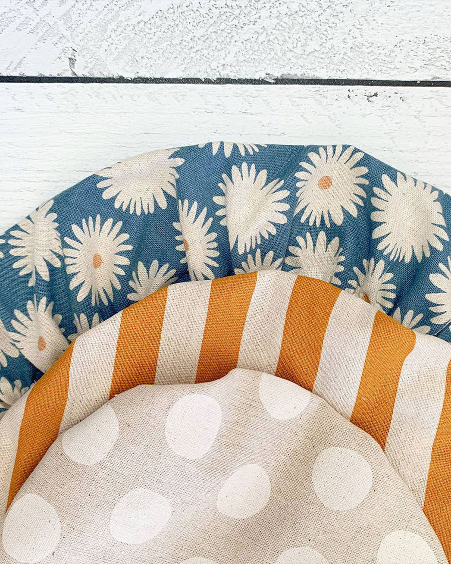 set of three fabric bowl covers: small white polka dots, medium gold and white stripe and large blue daisy