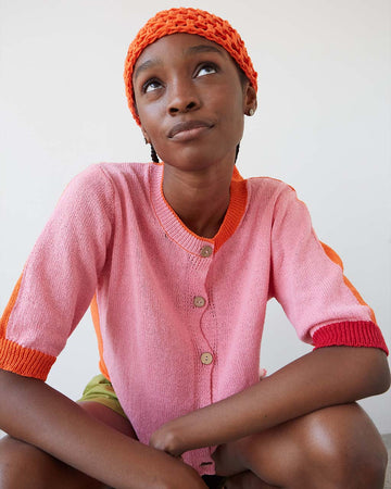 model wearing elbow length cardigan with bubblegum pink front and orange back