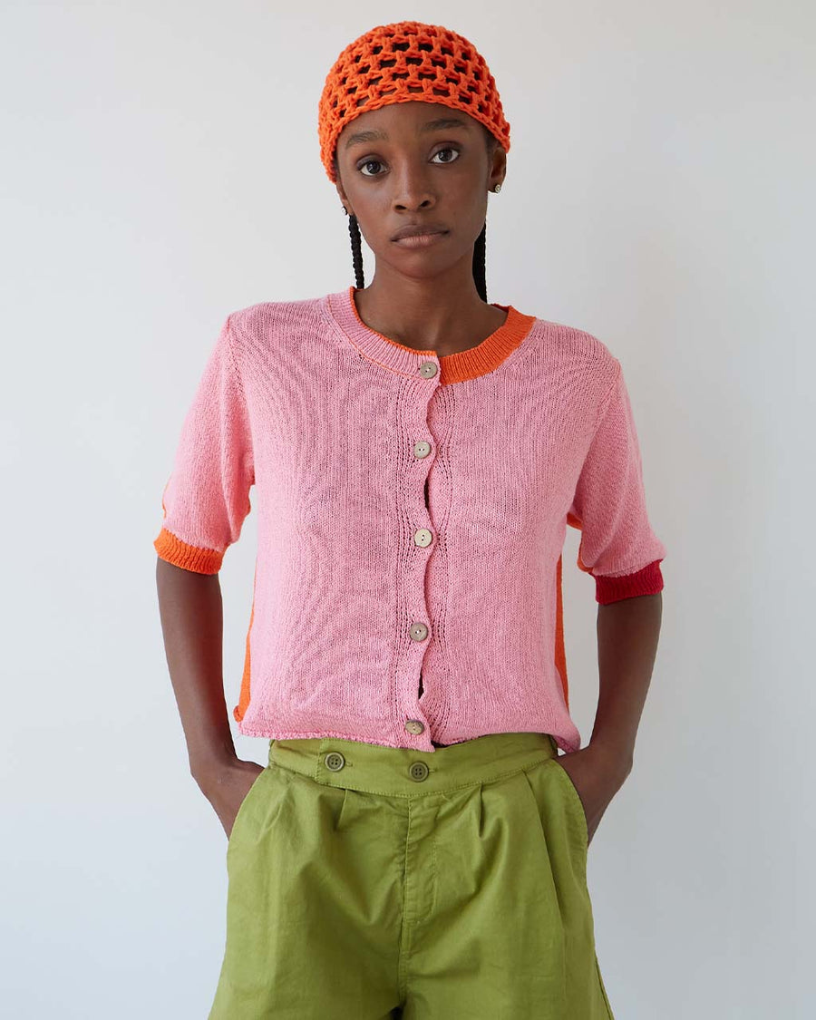 up close of model wearing elbow length cardigan with bubblegum pink front and orange back