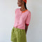 frontview of model wearing elbow length cardigan with bubblegum pink front and orange back