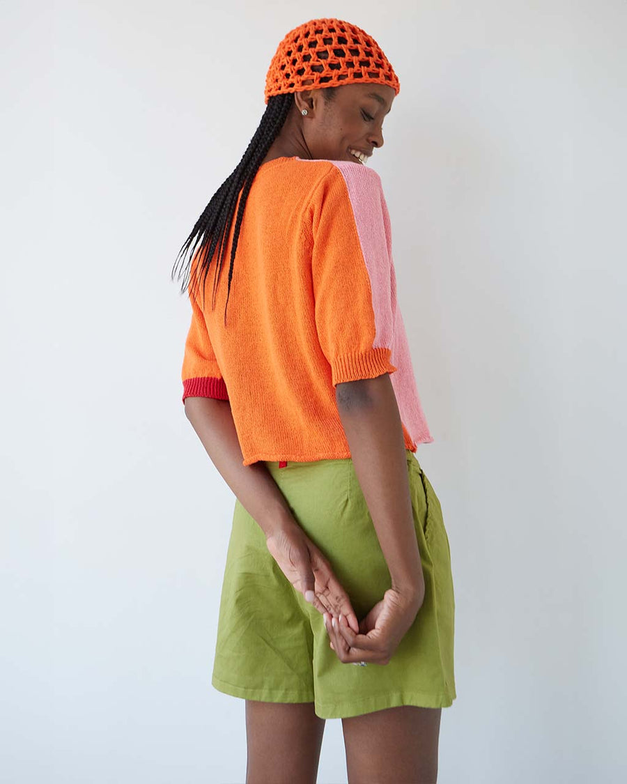 back view of model wearing elbow length cardigan with bubblegum pink front and orange back