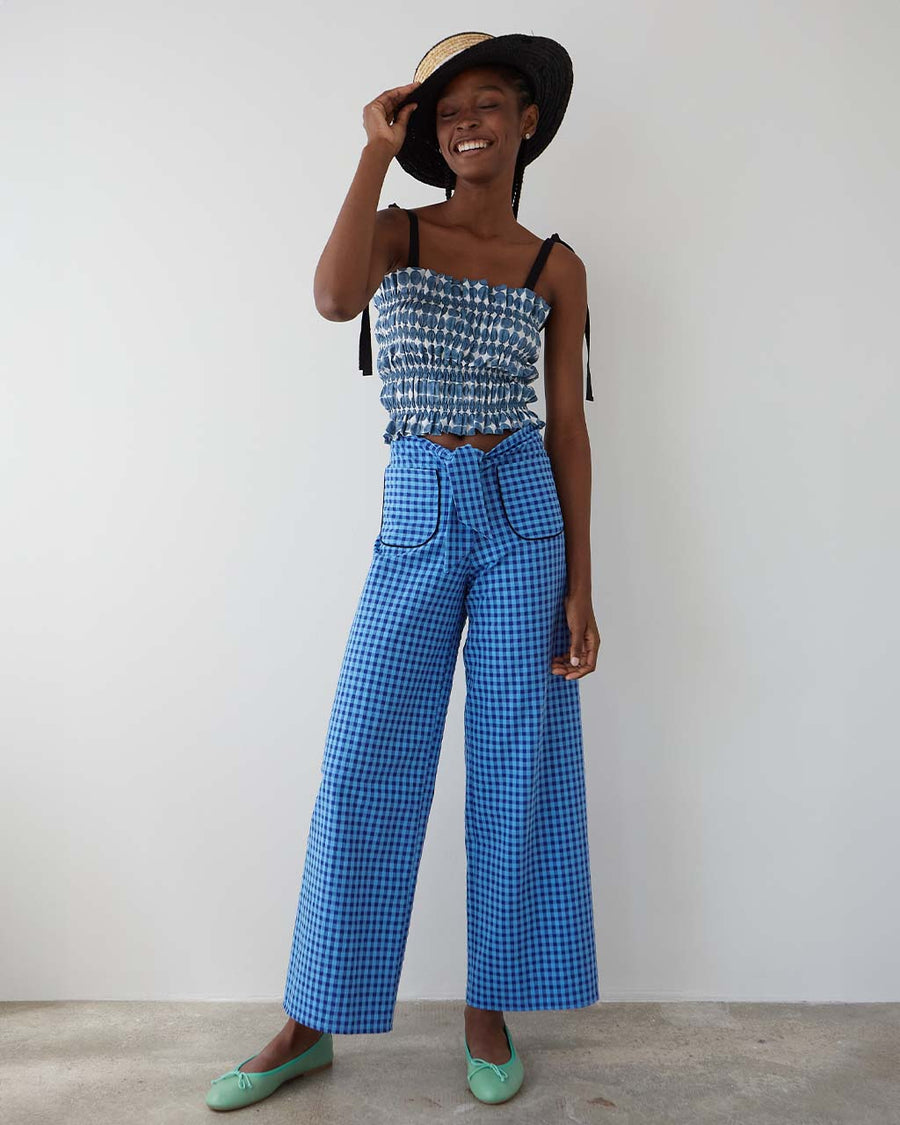 model wearing blue gingham pants with patch pockets with dark blue trim and tie waist