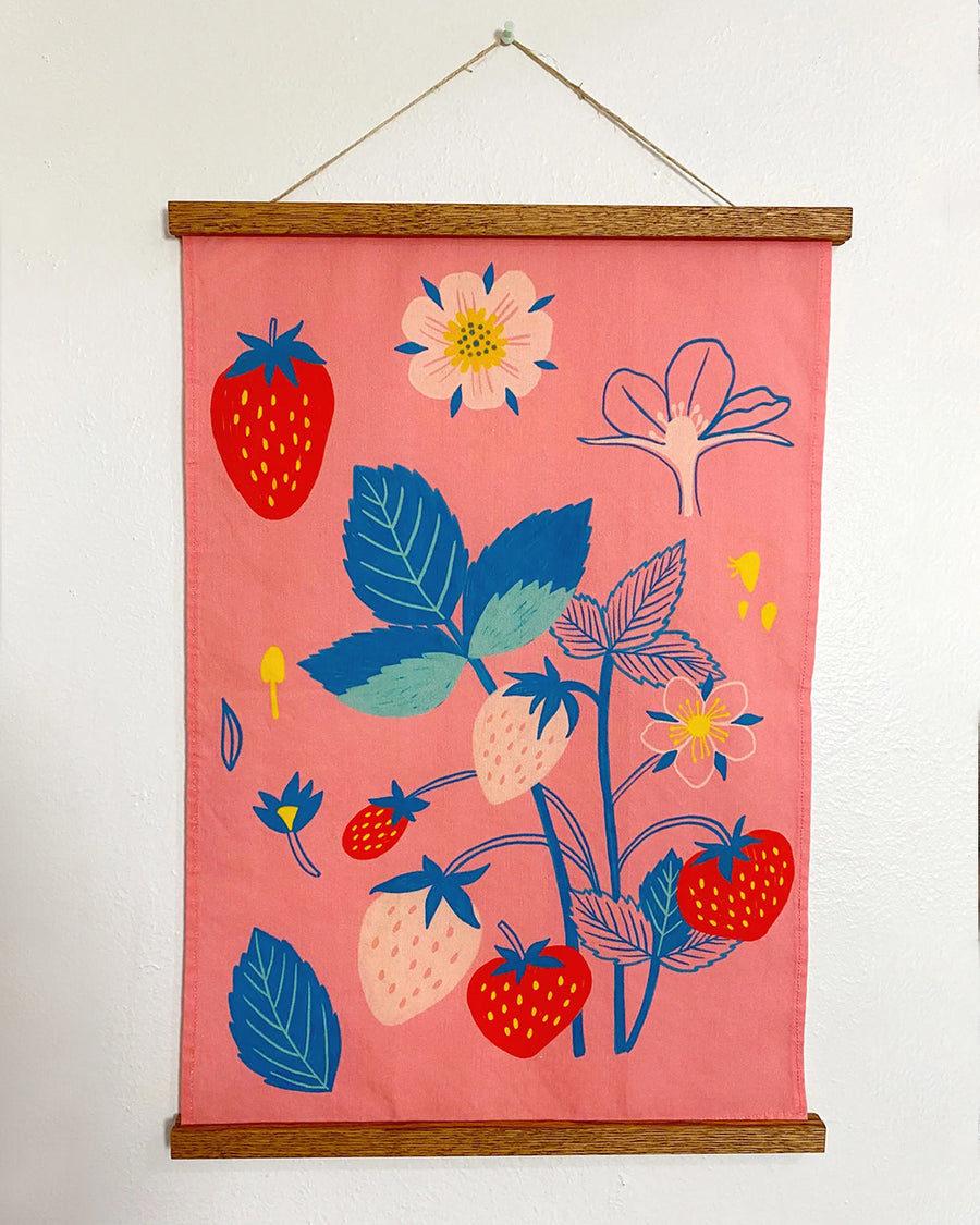 hanging pink tea towel with colorful strawberry print 
