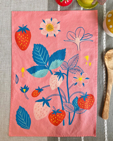 pink tea towel with colorful strawberry print