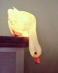 lit white duck looking down lamp