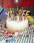 cake with oversize 'yippee' cake topper on old film