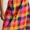 up close of model wearing colorful plaid midi skirt with colorful button front
