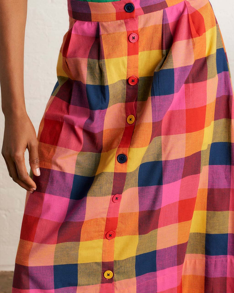 up close of model wearing colorful plaid midi skirt with colorful button front