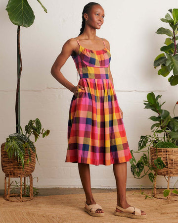 model wearing colorful plaid midi dress with fitted bodice and pockets