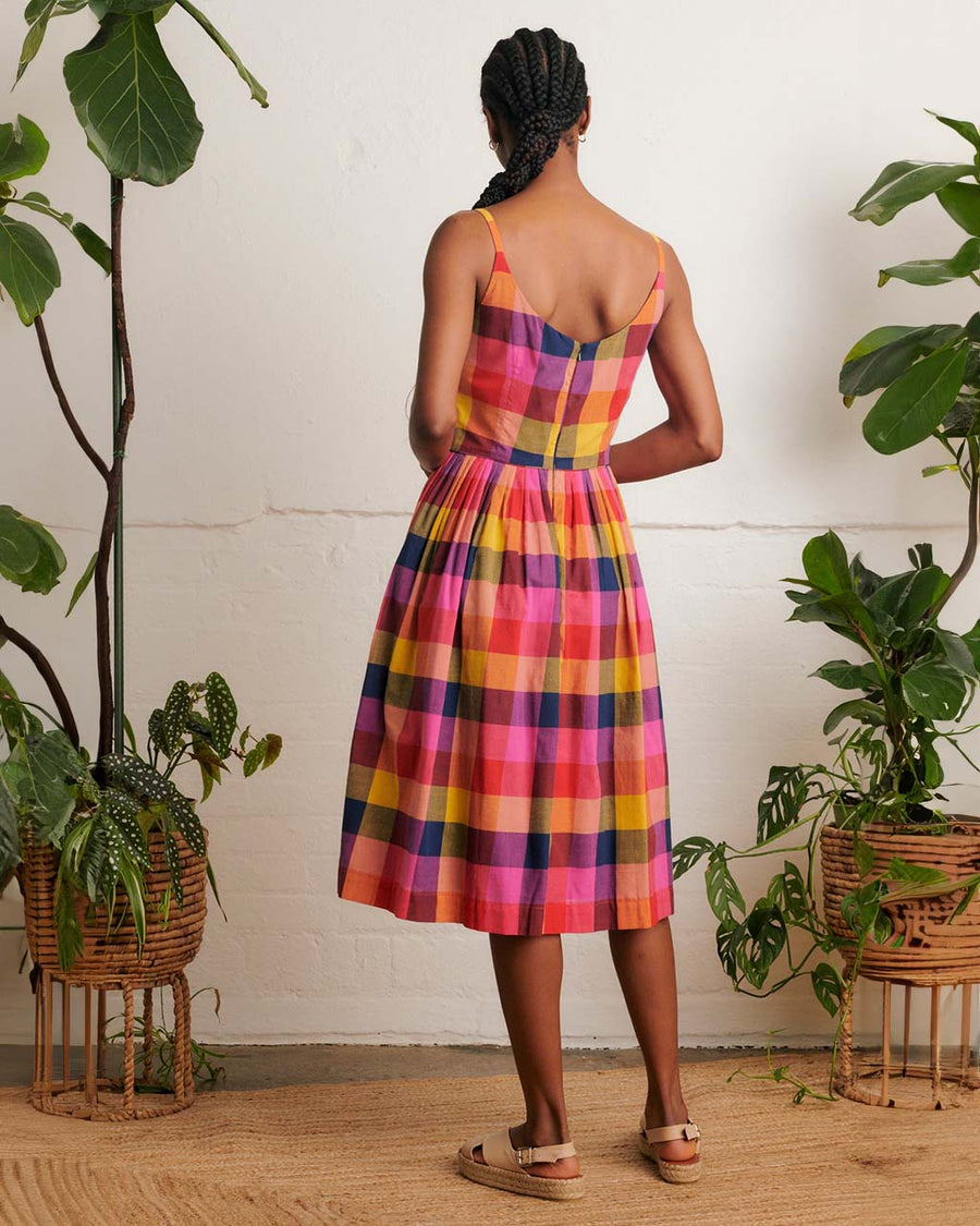 back view of model wearing colorful plaid midi dress with fitted bodice and pockets