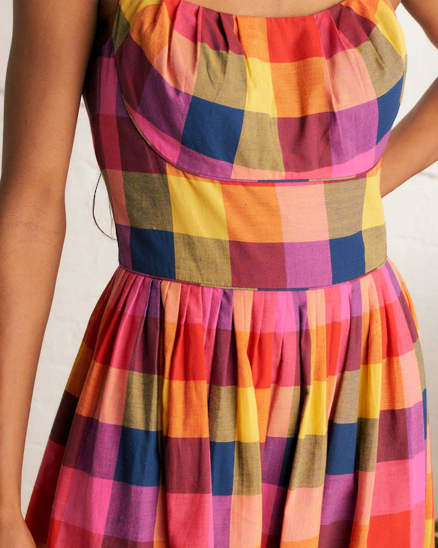 up close of model wearing colorful plaid midi dress with fitted bodice and pockets
