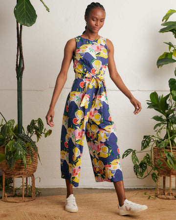 model wearing blue jumpsuit with picnic food print and tie waist