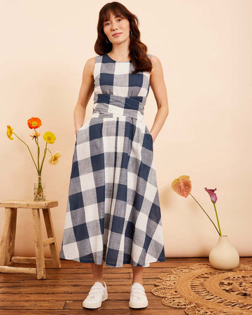 model wearing indigo and white plaid midi dress with wrap waist and thick tank straps