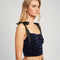 side view of model wearing navy velour cropped bustier tank with black tie straps