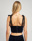 back view of model wearing navy velour cropped bustier tank with black tie straps and zip back