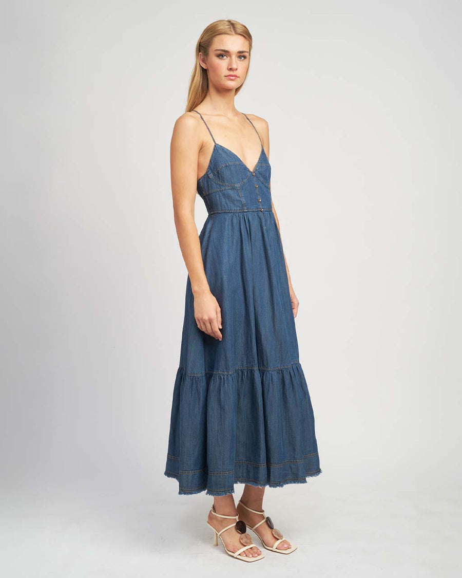 side view of model wearing denim midi dress with button front, spaghetti straps and o-ring back detail