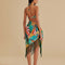 back view of model wearing teal beach sarong with colorful banana and banana leaves print and green fringe