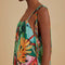 up close of model wearing green abstract print midi sundress with kerchief hem and tie shoulder straps