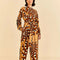 model wearing brown and gold abstract banana jumpsuit with patch pockets on bust and tie waist