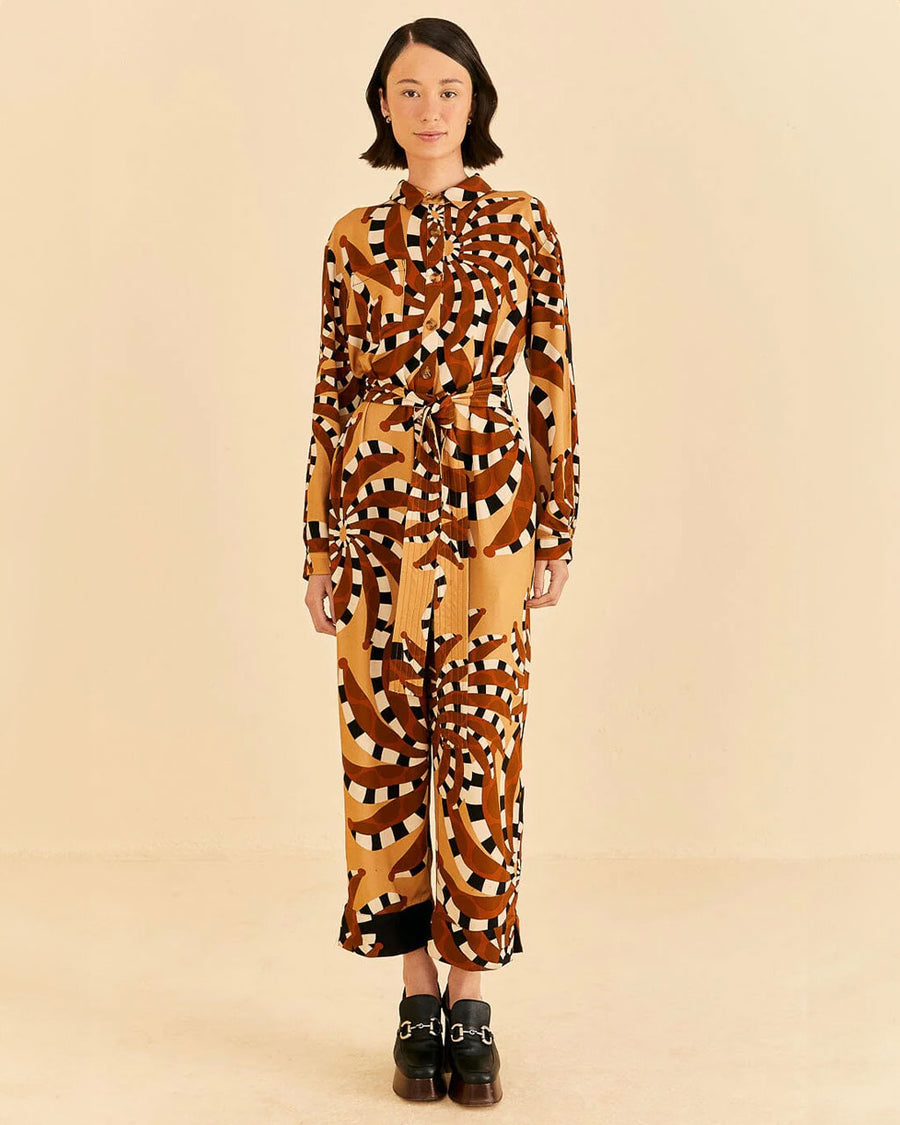 front view of model wearing brown and gold abstract banana jumpsuit with patch pockets on bust and tie waist