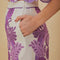 side view of model wearing white midi skirt with purple abstract floral and wavy hem and matching cropped blouse
