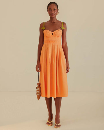 model wearing orange midi dress with corset bodice and green leaf straps