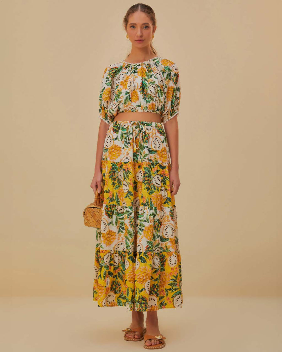 model wearing yellow and white mixed fruit tiered maxi skirt with tie waist and matching top