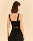 backview of model wearing black corset tank with flower textured detail