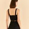 backview of model wearing black corset tank with flower textured detail