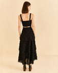 backview of model wearing tiered lace black maxi skirt with 3D flower textured detail and matching top