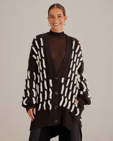 model wearing black oversized cardigan with textured white stripe pattern