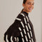 up close of model wearing black oversized cardigan with textured white stripe pattern
