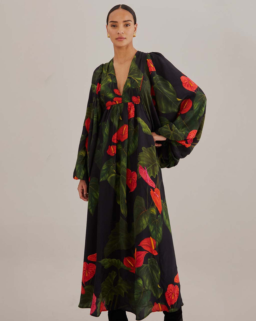 model wearing black maxi dress with puff sleeves, deep v and all over red floral print