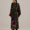 back view of model wearing black maxi dress with puff sleeves, deep v and all over red floral print