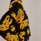 up close of model wearing black cropped cardigan sweater with yellow abstract banana print