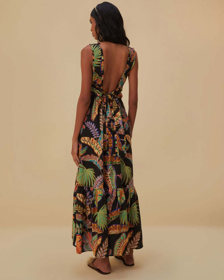 back view of model wearing black maxi sundress with button front, low tie back and vibrant foliage print