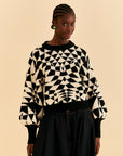 model wearing black and white abstract print sweater with balloon sleeves and slightly cropped fit