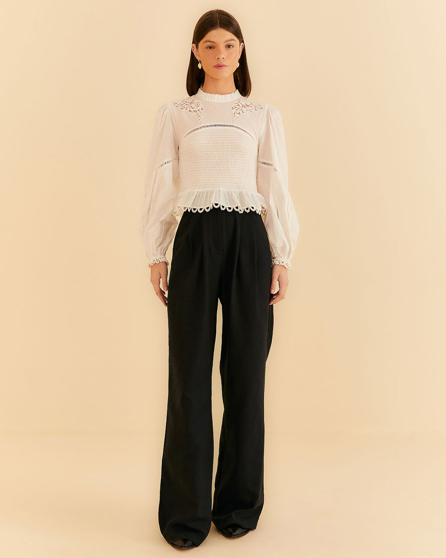 model wearing black wide leg pants with white blouse