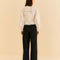 backview of model wearing black wide leg pants with white blouse