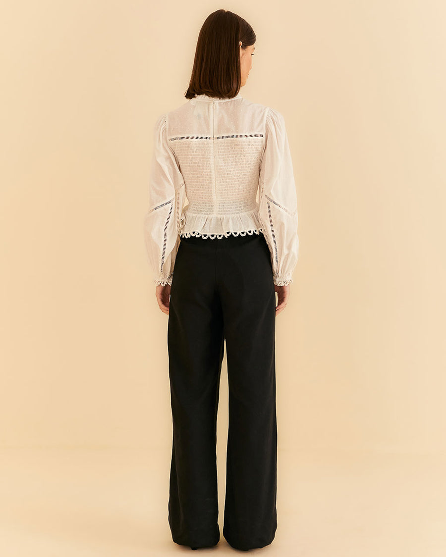 backview of model wearing black wide leg pants with white blouse