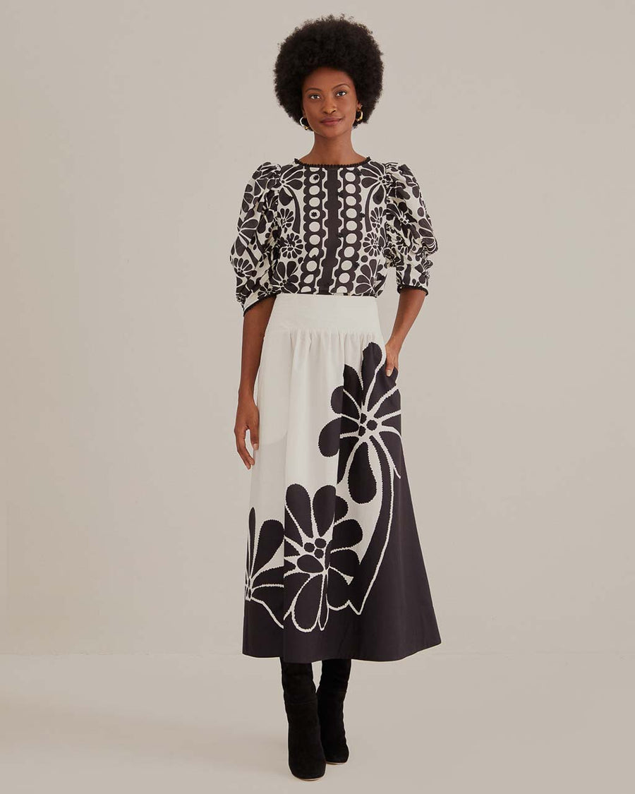 model wearing white midi skirt with black flower print